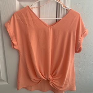 Coral blouse with tied knot on bottom. Size M